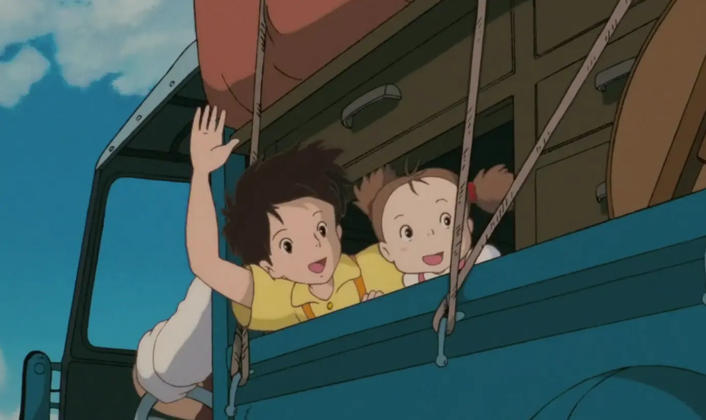 The figures in the picture are sitting in a forward moving car waving to the rear, their hair swaying from side to side in the wind